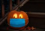 Lighted Jack-o-Lantern dressed up for Halloween with COVID Pande